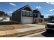 Two-story home with gray siding, brick accents, and a side view of the garage at 203 Arabella Pkwy, Locust Grove, GA 30248