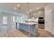 Modern kitchen with gray cabinetry, large island, and stainless steel appliances at 203 Arabella Pkwy, Locust Grove, GA 30248