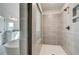 Modern tiled shower with glass door and built-in shelves, offering a luxurious feel at 203 Arabella Pkwy, Locust Grove, GA 30248