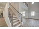 Elegant staircase with wrought iron railing leading to the second floor at 203 Arabella Pkwy, Locust Grove, GA 30248