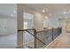 Upstairs hall with wood railing and carpet flooring at 203 Arabella Pkwy, Locust Grove, GA 30248