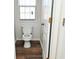 Simple toilet and wood floor in small bathroom at 2374 Suwanee Pointe Dr, Lawrenceville, GA 30043