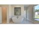 Bathroom with soaking tub, walk in shower, and marble tile at 443 Lothbury Ave, Locust Grove, GA 30248