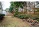 Partially wooded backyard with wood pile at 3955 Three Chimneys Ln, Cumming, GA 30041