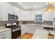 Modern white kitchen with stainless steel appliances and patterned backsplash at 1750 Derry Sw Ave, Atlanta, GA 30310