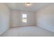 Cozy bedroom featuring neutral carpet, a window for natural light, and a ceiling light at 501 Dolce Rd, Locust Grove, GA 30248