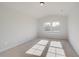 Bright bedroom features neutral carpet, two windows, and a ceiling light at 501 Dolce Rd, Locust Grove, GA 30248