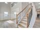 Bright foyer with wood-look floors, staircase, and an open view to the living spaces at 501 Dolce Rd, Locust Grove, GA 30248