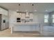 White kitchen with large island, stainless steel appliances, and pendant lighting at 501 Dolce Rd, Locust Grove, GA 30248