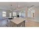 Open-concept kitchen with island, stainless sink, and an adjacent living area with fireplace at 501 Dolce Rd, Locust Grove, GA 30248