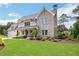 Beautifully landscaped front yard with lush green grass and mature trees surrounding an inviting two-story home at 2760 Rustic Lake Ter, Cumming, GA 30041