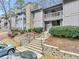 Condo building with stone fireplace and landscaping at 5031 Woodridge Way, Tucker, GA 30084