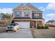 Two-story house with a gray and brick exterior, a two-car garage, and a well-manicured lawn at 100 Canyons Ct, Hampton, GA 30228