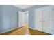 Bedroom with light blue walls, wood floors and double doors to closet at 729 Cedar Pointe Sw Ct, Marietta, GA 30008