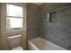 Bathroom with gray tile shower surround and a window at 2455 Ellijay Ne Dr, Brookhaven, GA 30319