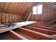 Unfinished attic space with exposed beams and large window at 2455 Ellijay Ne Dr, Brookhaven, GA 30319