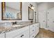 Bathroom vanity featuring double sinks, granite countertops, framed mirrors and white cabinetry at 337 Ellis Preserve Sw Ln, Marietta, GA 30064