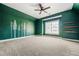 A room with hunter green walls, white trim, a ceiling fan, and two windows at 337 Ellis Preserve Sw Ln, Marietta, GA 30064