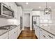 Well-equipped kitchen with stainless steel appliances, granite countertops, white cabinets and hardwood floors at 337 Ellis Preserve Sw Ln, Marietta, GA 30064