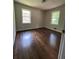 Inviting bedroom featuring hardwood floors and abundant natural light from two windows at 6625 Starling Sw Pl, Mableton, GA 30126