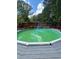 Backyard above ground pool with deck is surrounded by lush trees adding a relaxing atmosphere at 6625 Starling Sw Pl, Mableton, GA 30126