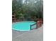 Backyard above ground pool surrounded by lush greenery and a wooden deck with safety fencing at 6625 Starling Sw Pl, Mableton, GA 30126