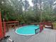 Backyard pool surrounded by a wooden deck, with a covered pergola for shade at 6625 Starling Sw Pl, Mableton, GA 30126