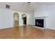 Spacious living room with hardwood floors, a fireplace, and arched doorways to the kitchen at 6715 Biscayne Blvd, Rex, GA 30273