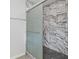 Bathroom shower featuring marble-patterned walls and a glass door with a stylish design at 1974 Browns Mill Se Rd, Atlanta, GA 30315