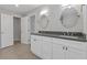 Bright bathroom with a double sink vanity, gray countertop, and oval mirrors at 1974 Browns Mill Se Rd, Atlanta, GA 30315