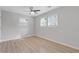 Bedroom with light wood flooring, three windows, and a ceiling fan at 1974 Browns Mill Se Rd, Atlanta, GA 30315