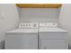 Laundry room with a washer, dryer, and a wood shelf above at 1974 Browns Mill Se Rd, Atlanta, GA 30315