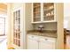 Convenient butler's pantry with granite countertop and glass-front cabinets at 63 Habersham Cove Nw Ln, Atlanta, GA 30305