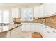 Modern kitchen with granite countertops, white cabinets, and tile backsplash at 63 Habersham Cove Nw Ln, Atlanta, GA 30305