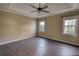 Main bedroom with wood-look floors, ceiling fan, and large windows at 758 Shoreline Se Trl, Conyers, GA 30094