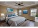 Main bedroom with wood-look floors, ceiling fan, and large windows at 758 Shoreline Se Trl, Conyers, GA 30094