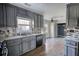 Renovated kitchen with gray cabinets, granite countertops, and stainless steel appliances at 758 Shoreline Se Trl, Conyers, GA 30094