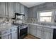 Renovated kitchen with gray cabinets, granite countertops, and stainless steel appliances at 758 Shoreline Se Trl, Conyers, GA 30094