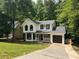 Charming two-story home with a manicured lawn, black windows, black door and an attached garage at 1126 Williamsburg Ln, Norcross, GA 30093