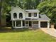 Charming two-story home with a manicured lawn, black windows, black door and an attached garage at 1126 Williamsburg Ln, Norcross, GA 30093
