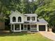 Charming two-story home with a manicured lawn, black windows, black door and an attached garage at 1126 Williamsburg Ln, Norcross, GA 30093