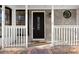 Inviting front porch with decorative front door, sidelight and transom window and stone veneer at 1126 Williamsburg Ln, Norcross, GA 30093