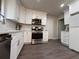 Modern kitchen featuring white cabinets, stainless appliances, and luxury vinyl floors at 1126 Williamsburg Ln, Norcross, GA 30093