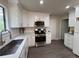 Modern kitchen features white cabinets, stainless steel appliances, and bright countertops at 1126 Williamsburg Ln, Norcross, GA 30093
