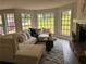 Sunlit living room features a stone fireplace, plush sofa, bay window, and gray rug at 1126 Williamsburg Ln, Norcross, GA 30093
