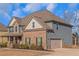 Another side view of the two-story home highlighting the garage and landscaping at 149 Elkins Blvd, Locust Grove, GA 30248