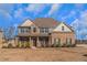 Two-story brick home with gray siding, a large front porch, and a landscaped yard at 149 Elkins Blvd, Locust Grove, GA 30248