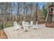 Backyard patio seating area featuring a stone fire pit and wooden staircase to a deck at 1525 Haddenham Dr, Cumming, GA 30041