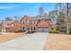 Expansive driveway leading to a brick home with a two-car garage at 1525 Haddenham Dr, Cumming, GA 30041