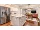 Well-equipped kitchen with stainless steel appliances and island adjoins dining area at 1525 Haddenham Dr, Cumming, GA 30041